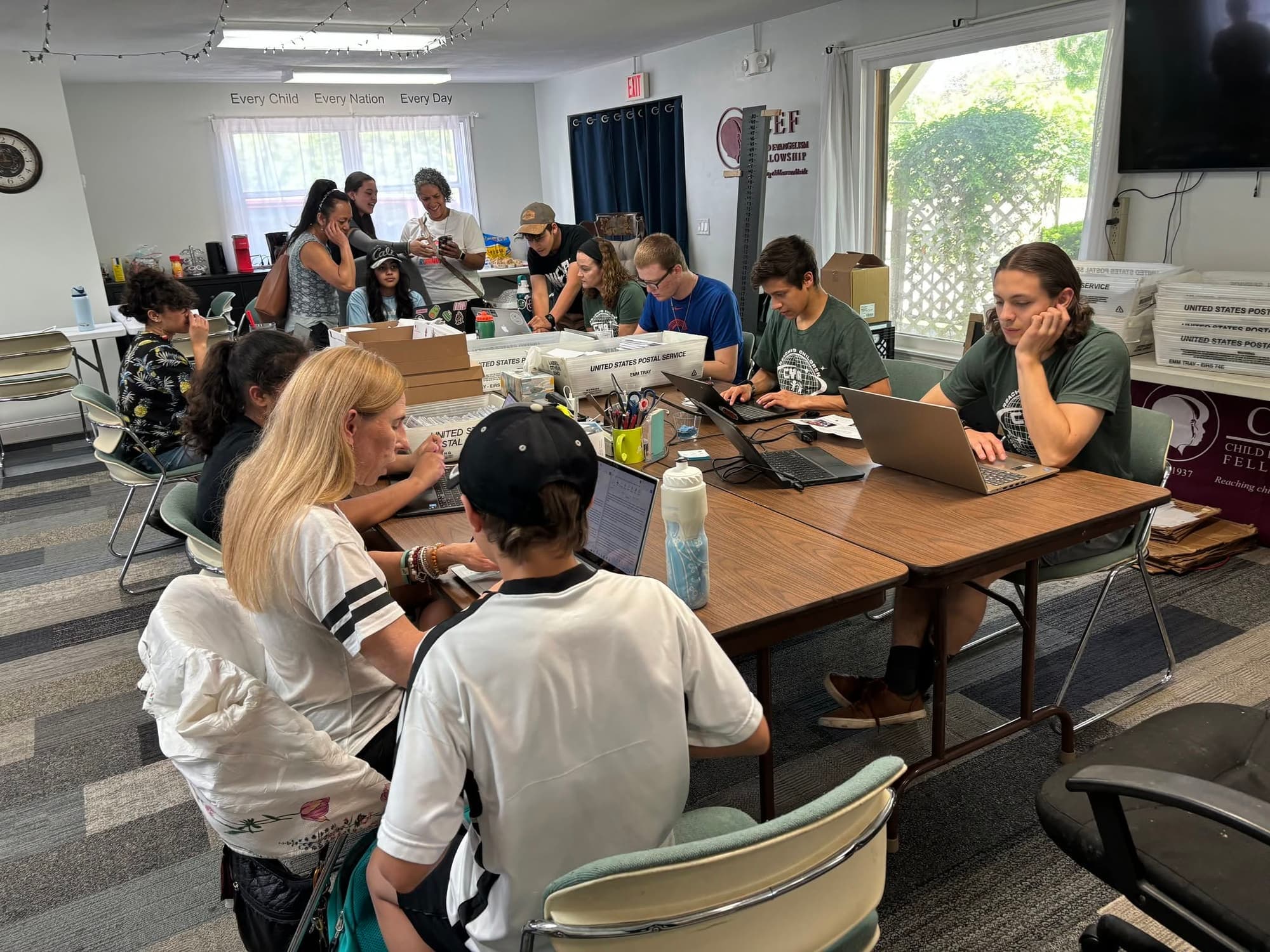 Staff and volunteers work together around a long table in the CEF Chicago office